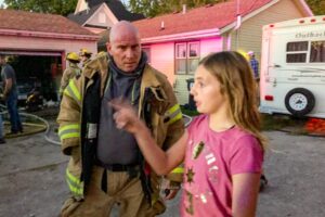 Oskaloosa Fire Chief Scott Vaugh listens as Lily Woods describes what she saw before she called 911.