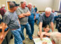 Jim Van Zomeren and his daughter Anna Schafer (right) look at a map of the airport with Jerry Searle, a planner with HDR, while other landowners discuss in the background.