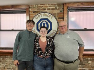 Oskaloosa Optimist president, R.D. Keep, right, presented Oskaloosa seniors Elliott Nelson and Abigail Lindgren with a $500 check on behalf of the club to defray expenses for their participation in a national Congressional debate contest in Mesa, Ariz.