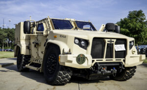 A Joint Light Tactical Vehicle rests at low suspension while on display at the Camp Dodge Summer Concert Series in Johnston, Iowa, on June 29, 2023. Earlier this year, the Iowa Ordnance Training Center at Camp Dodge received three Joint Light Tactical Vehicles, a new series of military vehicles designed for survivability and tactical mobility. Weighing in at around 13,800 pounds (give or take depending on its configuration), the vehicle sports a futuristic exterior with advanced computer technology integrated throughout its structure that makes it uniquely capable to handle heavy loads and protect service members from outside attacks. (U.S. Army National Guard photo by Staff Sgt. Tawny Kruse)