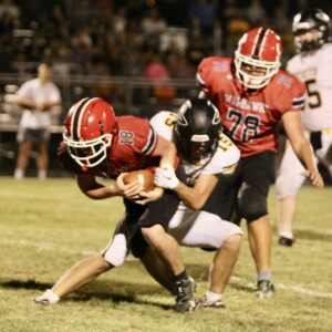 North Mahaska’s Kaleb Stout digs for yards as Eddyville-Blakesburg-Fremont’s Thomas McCrea holds on. Stout rushed for 64 yards to help NM to a 22-6 victory over the Rockets in the season opener Friday.
