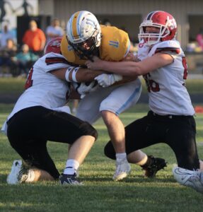 RD Keep Photo/ NM CommunicationsNorth Mahaska Trenton Hol and Austin McMahan wrap up Lynnville-Sully’s Corder Noun Harder for a short gain in the first quarter . L-S won the contest 48-0.