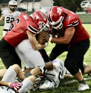 RD Keep/NM Communications photoNorth Mahaska’s Chance Angle and Gage VandeVoort wrap up Wayne’s Corydon Kiefer for a short gain. North Mahaska picked up its second win of the season 21-12 on senior night. 