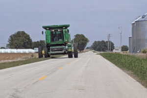 President Joe Biden and administration officials are kicking off an “Investing in Rural America” event series, starting with a visit to a Minnesota farm Wednesday. Shown is farm equipment rolling down an Iowa highway as harvest gets underway. (Photo by Jared Strong/Iowa Capital Dispatch)