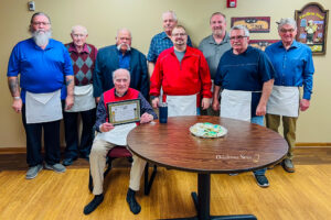 Bob Jones (seated) received a document commemorating his 75 years with Mahaska County Lodge 644.