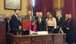 Iowa Gov. Kim Reynolds signed into law a measure making changes to Iowa’s Area Education Agencies, setting the school funding rate for the upcoming school year and raising teacher pay on March 27, 2024. (Photo by Robin Opsahl/Iowa Capital Dispatch)