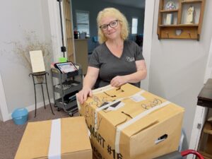 Sheila Guiter is seen here packing up donations from their current location for storage.