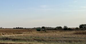 A tractor during corn harvest in a field alongside east-bound Interstate 80. (Cami Koons / Iowa Capital Dispatch)