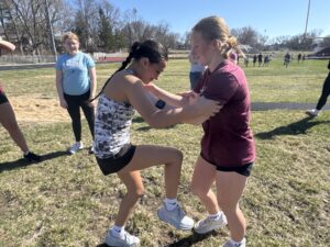 Oskaloosa High School girls track athletes practice self-defense techniques with each other during a hands-on training led by Navy SEAL veteran Clay Grandia. The session focused on building confidence, awareness, and practical skills to help students protect themselves in real-life situations.