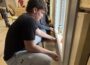 Students in the Construction Trades program gain hands-on experience as they build a house from the ground up. Senior Maddox Ashman installs light switches and outlets, Lukas Toubekis measures and trims interior finishes, and Jaden DeRonde secures cabinets. The project provides real-world skills that prepare students for careers in the construction industry.