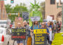 Protestors march around the Oskaloosa town square, voicing concerns over executive overreach, trade policy, and threats to democratic institutions.