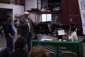  Federal Trade Commissioner Alvaro Bedoya, right, speaks with Iowa Farmers Union President Aaron Lehman, center, and Josh Manske, left, at an event with IFU members in Ankeny June 7, 2025. (Photo by Cami Koons/Iowa Capital Dispatch) 