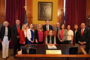  Gov. Kim Reynolds was joined by Iowa Secretary of State Paul Pate, legislators and county auditors in her office June 2, 2025 as she signed into law two bills from the 2025 legislative session related to Iowa elections. (Photo courtesy the Iowa Secretary of State’s office)