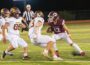 Oskaloosa quarterback Tyler Edgar scrambles from Mt. Pleasant defenders on Friday night.