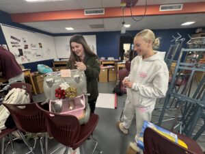 Oskaloosa High School Peer Helpers sort, prepare, and wrap winter clothing and holiday gifts for elementary students, carefully matching sizes and favorite colors as they turn each package into a thoughtful reminder of care, dignity, and community during the holiday season.