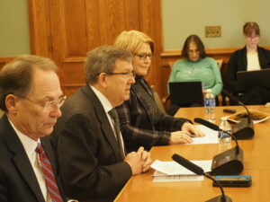  Members of the Revenue Estimating Conference, from left, Jeff Plagge, director of Northwest Bank in Spencer; Kraig Paulsen, the state budget director, and Jennifer Acton, director of the Fiscal Services division of the Legislative Services Agency, discussed projected state finances Dec. 11, 2025, at the State Capitol. (Photo by Robin Opsahl/Iowa Capital Dispatch)