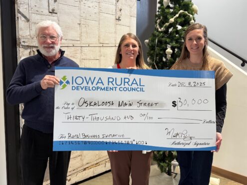 Deann De Groot, executive director of the Mahaska Chamber and Development Group, accepts a $30,000 Rural Business Initiative grant check from Mark Reinig, Iowa Rural Development Council board chair and Madison Burke, chair-elect. The funding, approved with support from the state’s Empower Rural Iowa task force, will support the Ignite Oskaloosa initiative, providing training, technical assistance, and grant opportunities for local small businesses and startups as the community prepares to celebrate 40 years as a Main Street community.