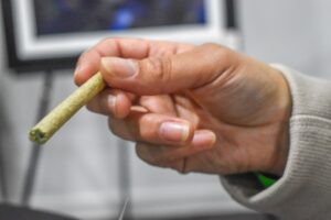  A cannabis pre-roll is held at a legalization anniversary party in Cranston, Rhode Island, Dec. 1, 2023. (Photo by Christopher Shea/Rhode Island Current)