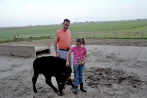  Emma Yerkey and her dad, Tim Yerkey, with the ribbon-winning calf they raised together. (Photo courtesy of Emma Yerkey)