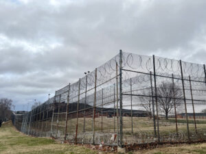 Barbed wire and fences surround the Charles H. Hickey Jr. School, a juvenile detention center in Maryland. Juvenile justice is one of the focuses of criminal justice legislation nationwide this year, including in Maryland, where lawmakers are considering a bill that would reduce the number of juveniles charged as adults. (Photo by Amanda Watford/Stateline)
