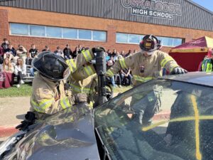 Oskaloosa High School students and community first responders participate in a mock crash demonstration on campus, illustrating the real-life consequences of distracted driving ahead of graduation. 