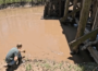 Ryan Kunkle collects water from the Middle River in Warren County to test for nitrates. (Screenshot from video by Zach Sommers for Iowa Capital Dispatch)
