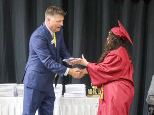 Oskaloosa School Board President Matt Sherlock congratulates a member of the Oskaloosa High School Class of 2026 while presenting diplomas during commencement ceremonies Sunday afternoon at the OHS gymnasium. (submitted photo)