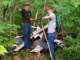 Wyatt DeCook, left, and a friend remove scrap metal and other discarded materials from a wooded area at Cedar Bluffs Natural Area near Oskaloosa. DeCook and several volunteers have removed more than 2,600 pounds of metal and debris from the conservation area in recent weeks.