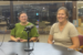 Lilia Morris and Carrie Bihn seated behind microphones during an Oskaloosa News interview about The Hub.