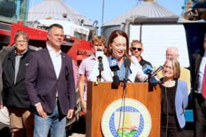  U.S. Secretary of Agriculture Brooke Rollins, center, at a farm near Prairie City, Iowa, Oct. 6, 2026 speaking about USDA seed sovereignty program alongside Iowa Reps. Zach Nunn, front left, and Mariannette Miller-Meeks, right. (Photo by Cami Koons/Iowa Capital Dispatch) 